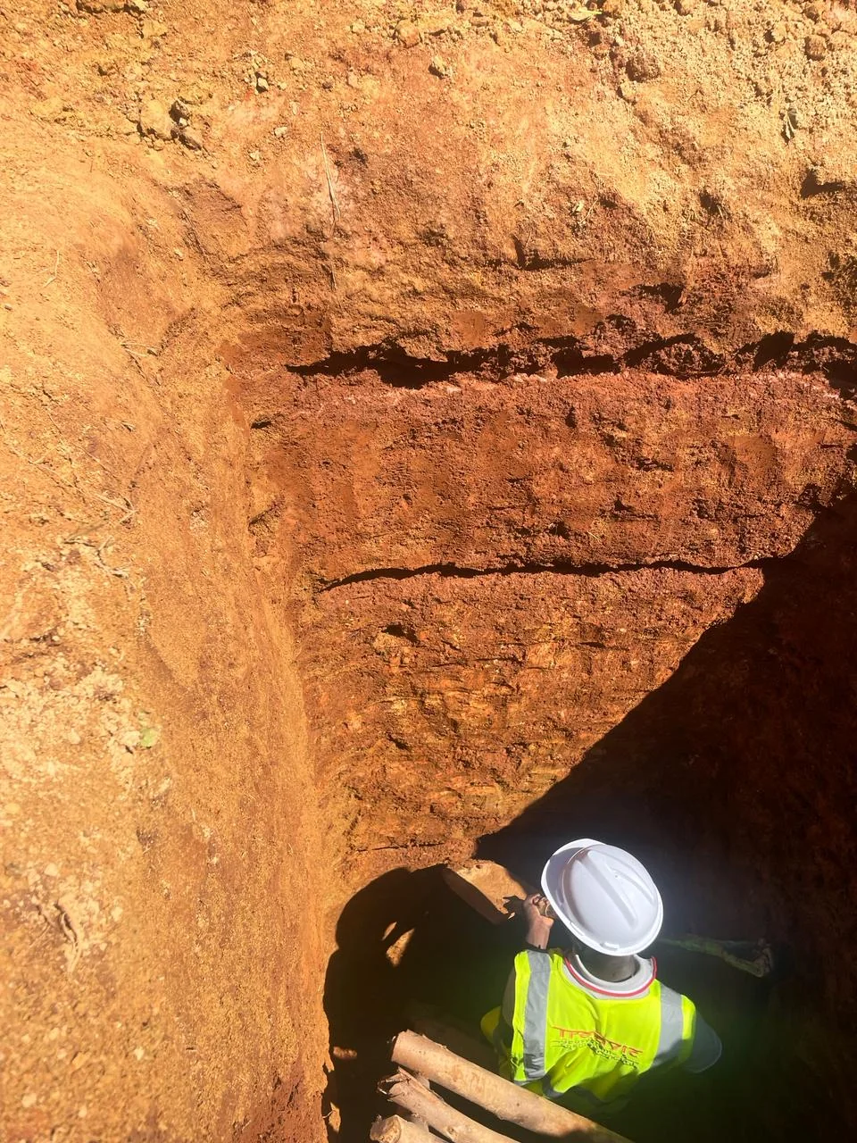 Site crew in safety gear inspecting ground conditions